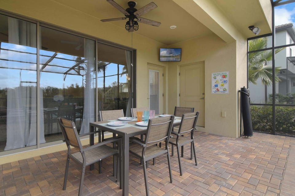 Covered outdoor dining area with seating for six and a ceiling fan