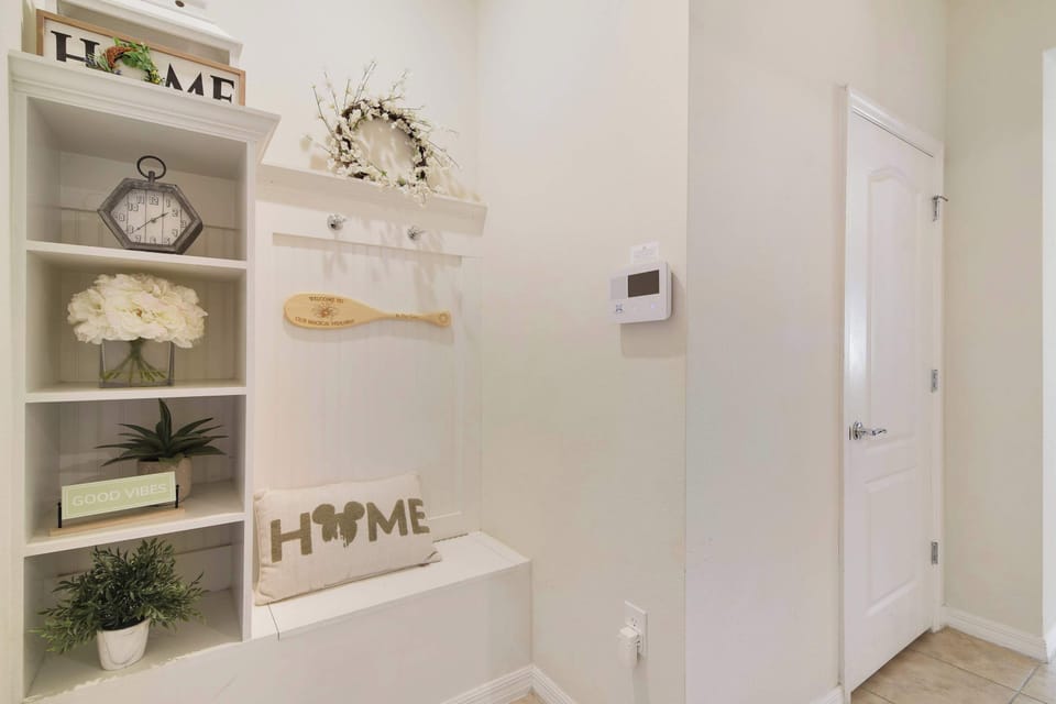 Cozy entryway nook with decorative shelving and seating.