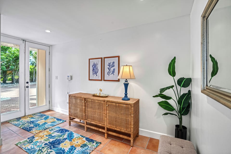 Feel the airy openness as you glance back toward the front door, welcoming sunlight and coastal charm.