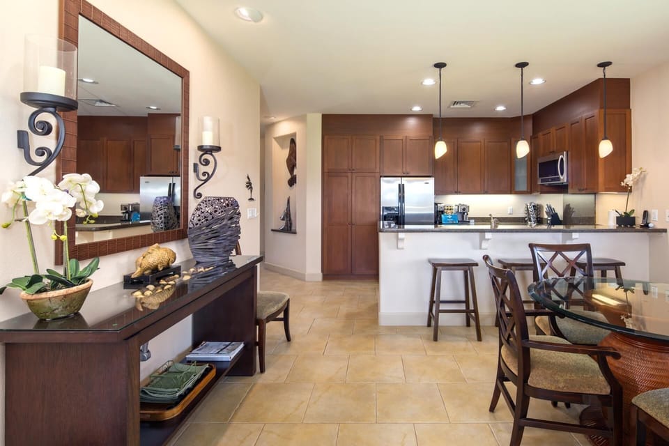 Sleek kitchen with rich wood cabinetry, pendant lighting, and stainless steel appliances     HLI-12A