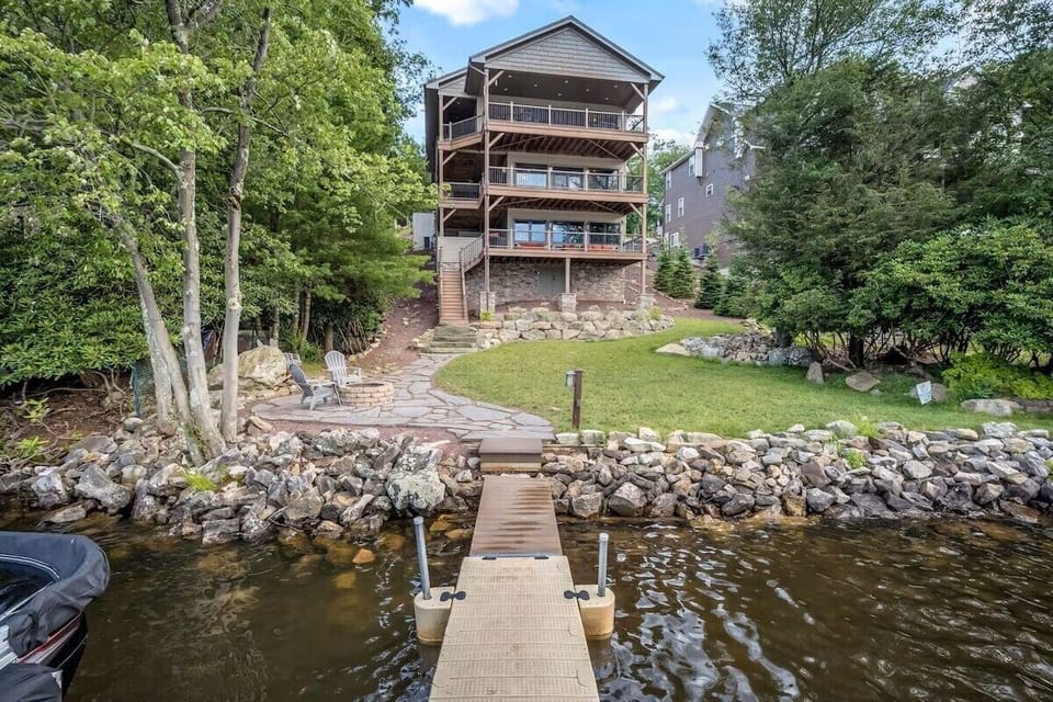 Luxury lakefront home with triple decks, private dock, firepit, and views.