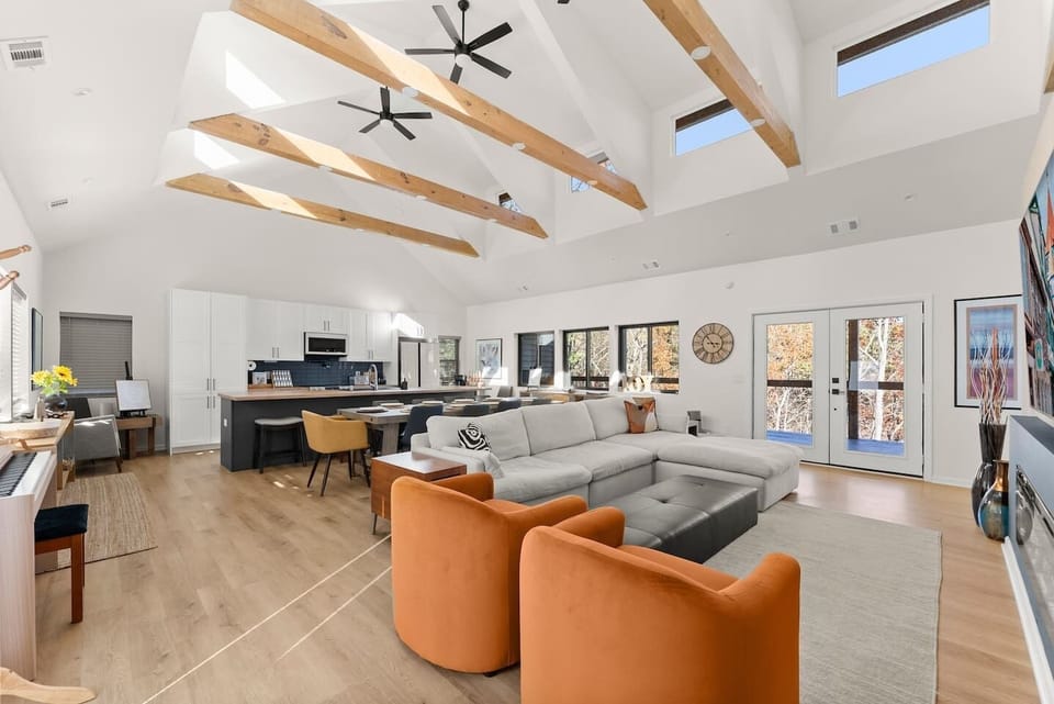 Bright, open-concept living, dining, and kitchen area with high ceilings and crisp white design—perfect for gathering and entertaining.