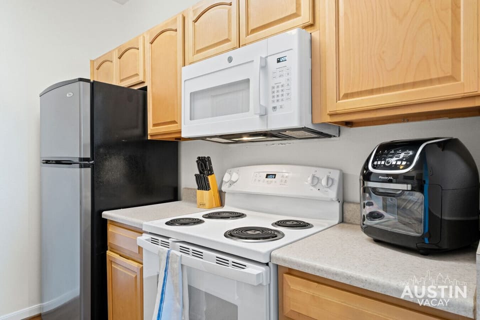 Fridge, stove, microwave, air fryer, all lined up and ready to perform