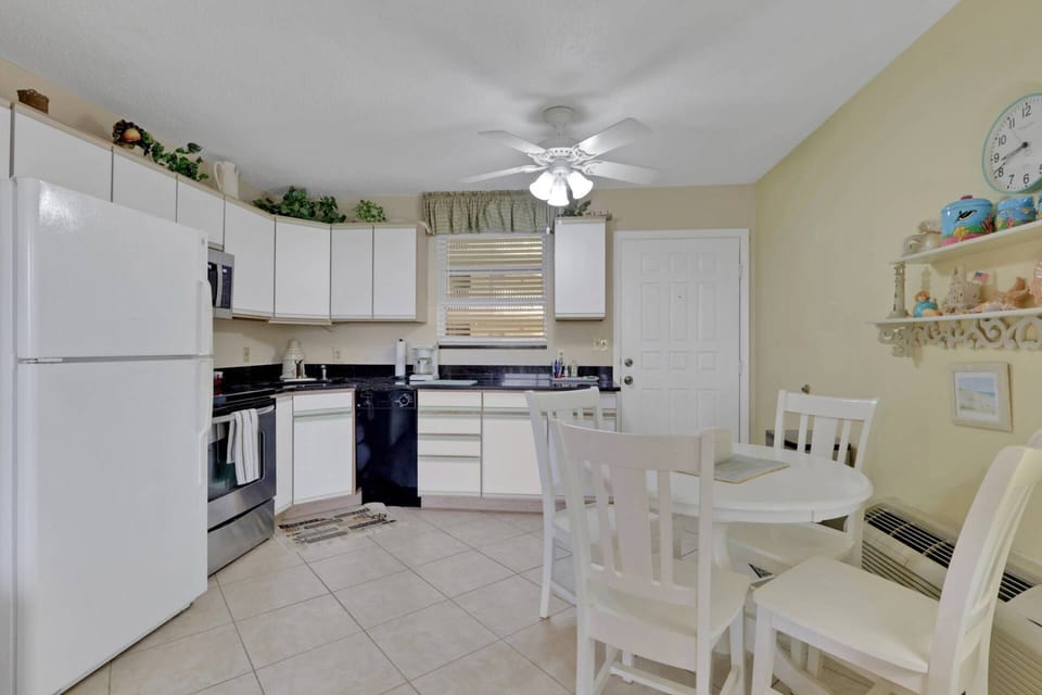 A dining table with seating for 4 is in the open kitchen space.