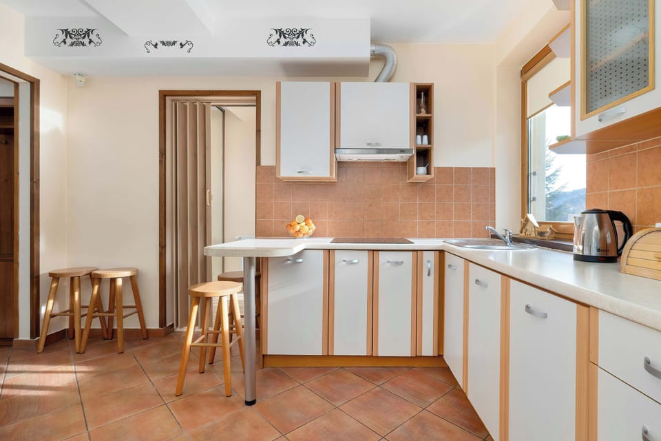 Spacious kitchen featuring light cabinetry, appliances, and a dining counter.