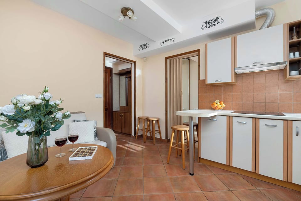Fully equipped kitchen with wooden cabinets, a stove, and a dining area.