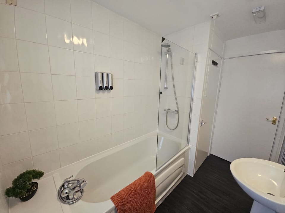 Bathroom with bath with shower over