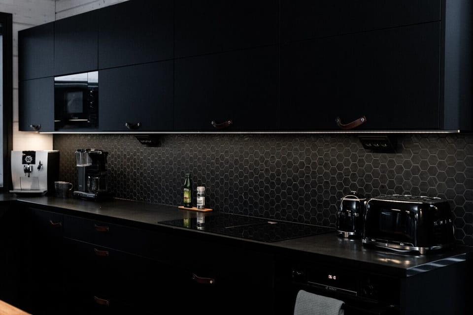 Modern kitchen with dark cabinets, combining elegance and functionality for a stylish cooking space.