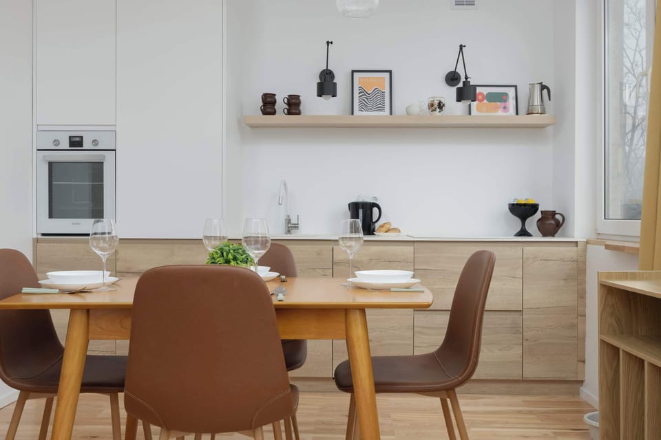 Inviting dining space with a wooden table, elegant brown chairs and natural daylight streaming in.