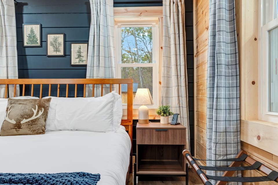 Cozy bedroom with a king bed, soft linens, and warm cabin charm.