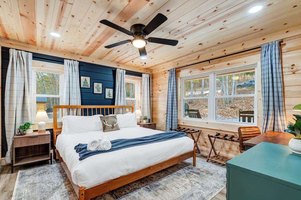 Cozy bedroom featuring a plush king bed, soft lighting, and woodland views.