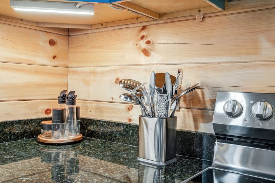 Fully stocked kitchen with essential utensils and spices.