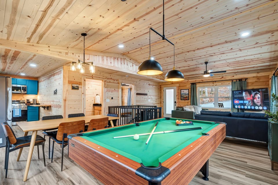 Cozy and inviting open space featuring a pool table and dining area.