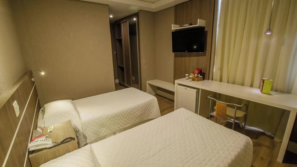 Recharge comfortably with twin beds, workspace, and soft lighting.