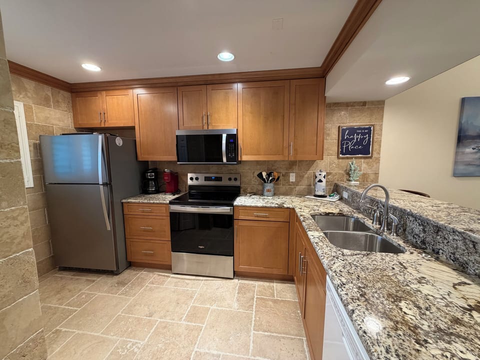 Your fully equipped kitchen awaits with granite countertops, stainless steel appliances, and warm wood cabinetry—perfect for preparing memorable meals together.