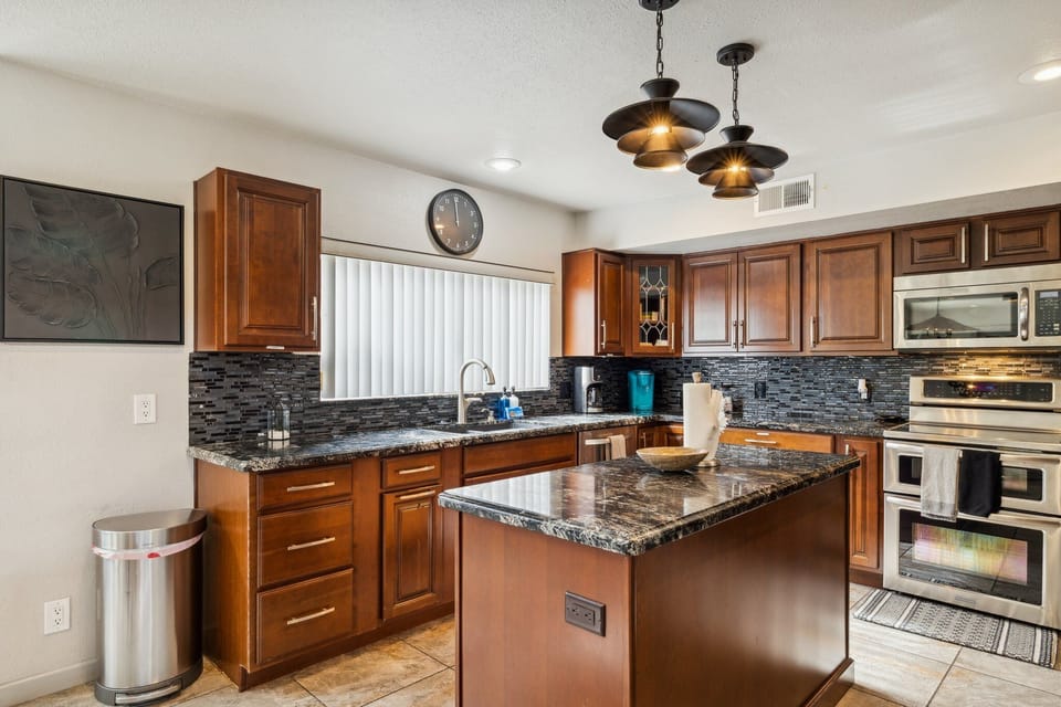 Spacious kitchen with wood cabinets, granite counters, and modern appliances.