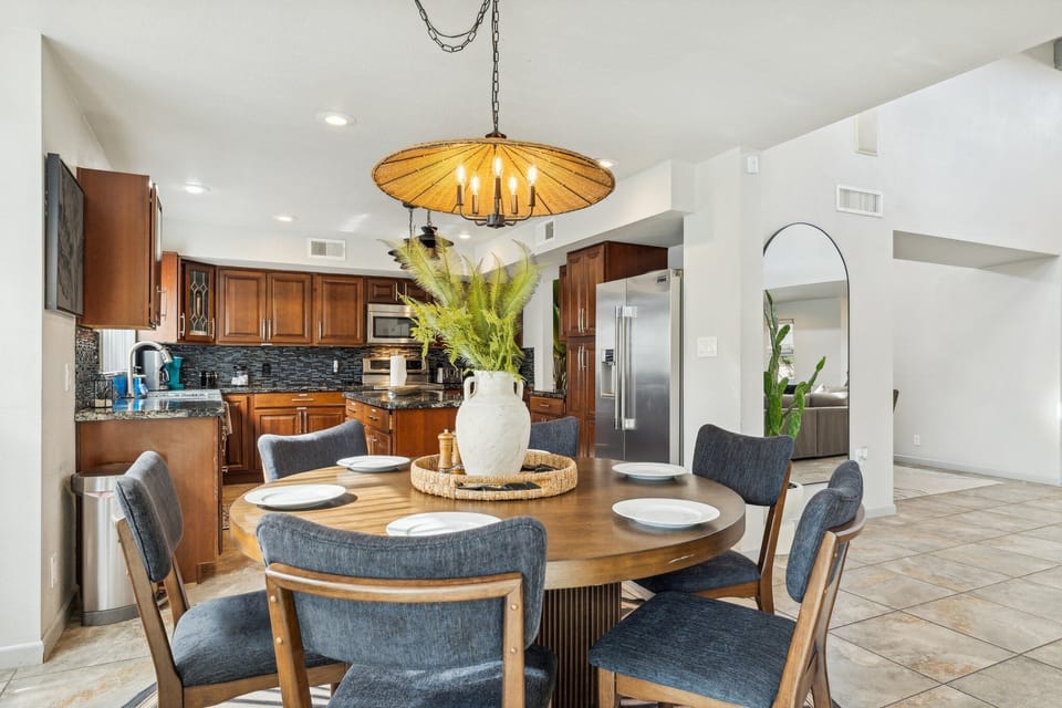Spacious kitchen featuring granite counters, modern appliances, and dining set.