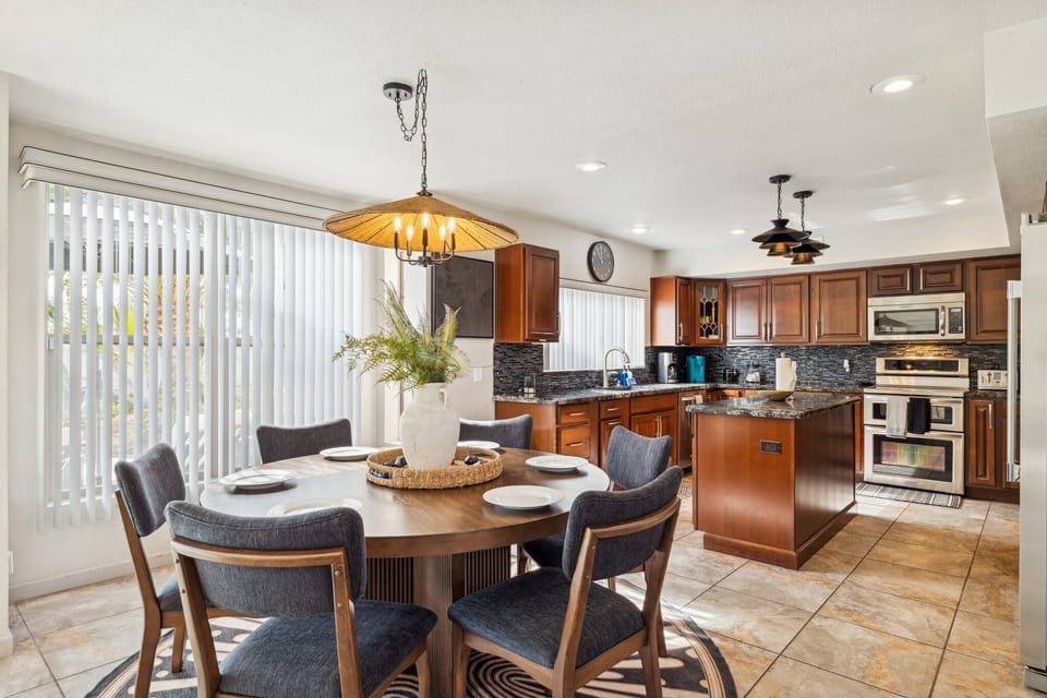 Bright kitchen with rich wood cabinets, island, and stylish dining area.