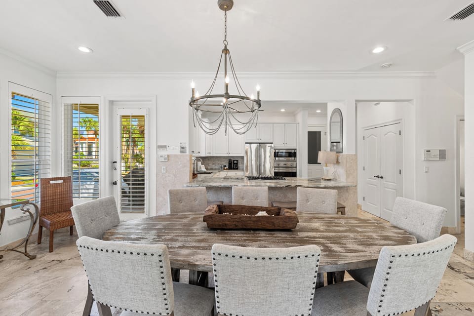 Gather around this stunning dining table where memorable meals unfold beneath elegant chandelier light, with your gourmet kitchen ready for culinary adventures.