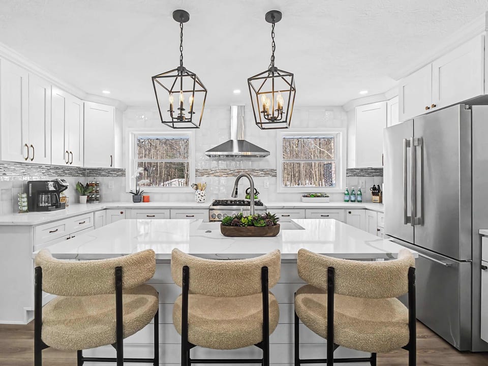 Bright kitchen w/ island seating, pendant lighting & clean white cabinetry