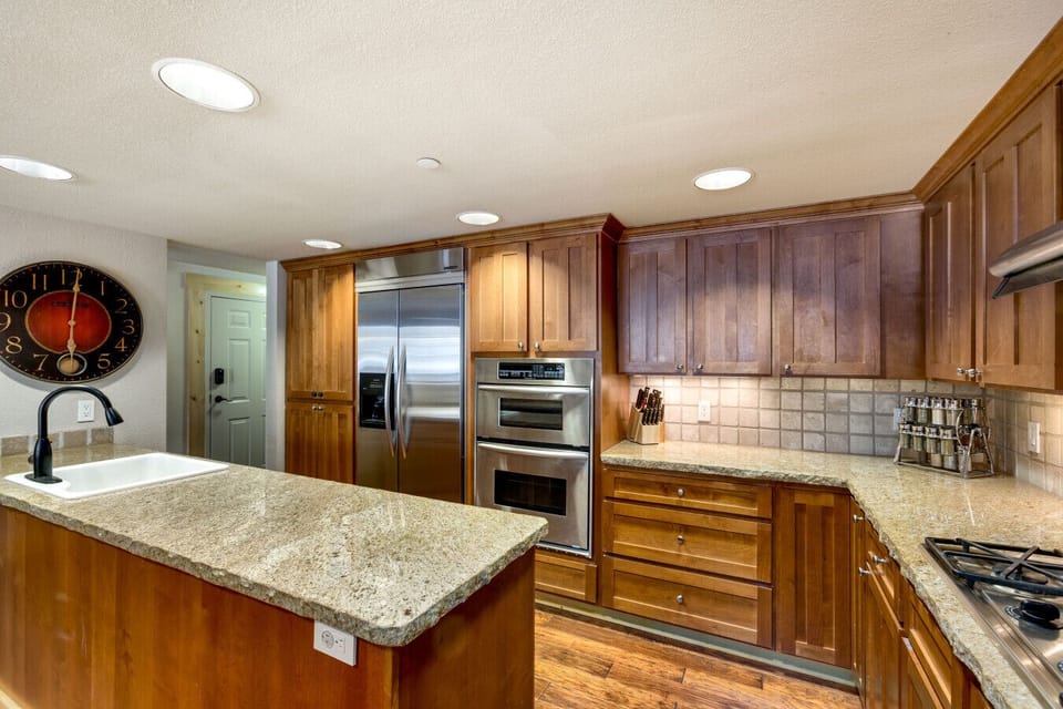 Spacious and inviting kitchen with granite countertops, ideal for preparing meals or entertaining guests in your mountain retreat