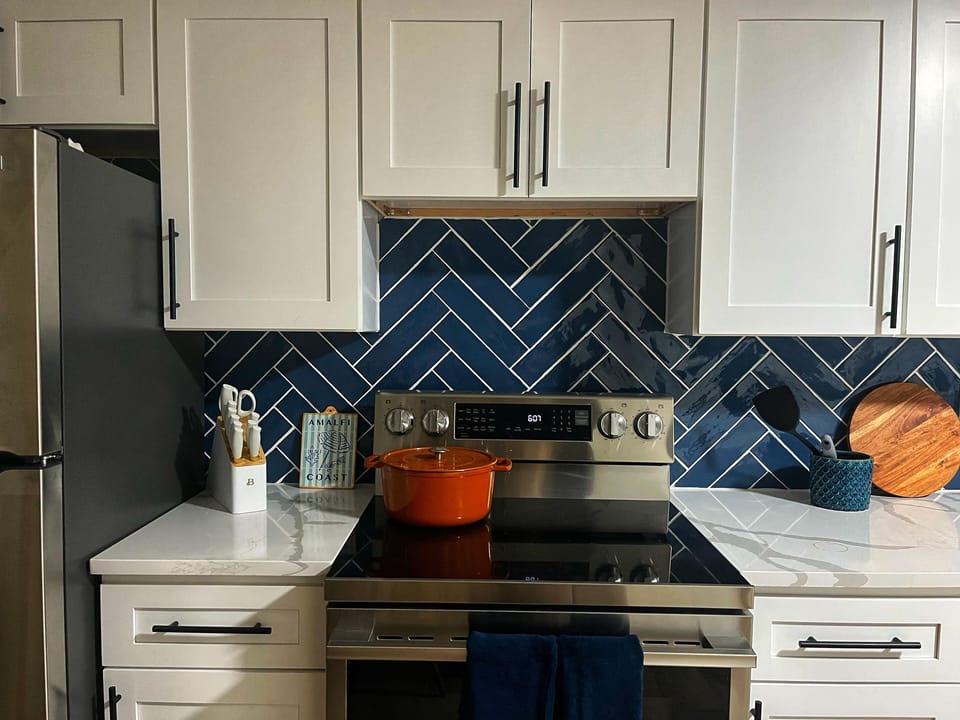 Glass-top stove and oven with counterspace and cooking/baking tools.