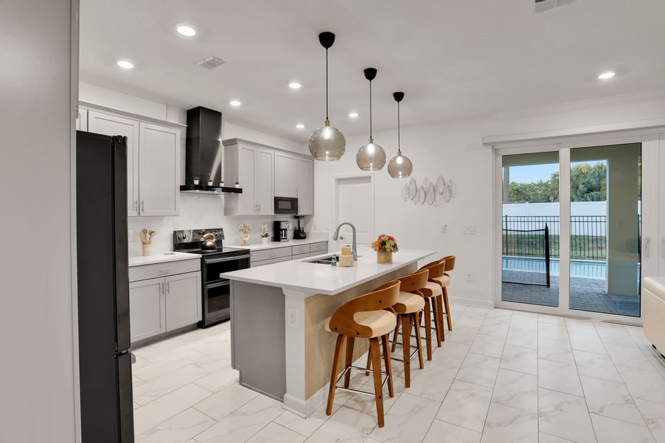 Spacious kitchen layout with sliding glass doors that lead to outdoor pool & patio