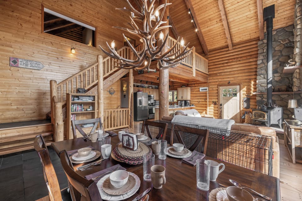There is a large dining room table with comfortable seating for 6, board game and bookshelves, and two large dog crates for furry family.