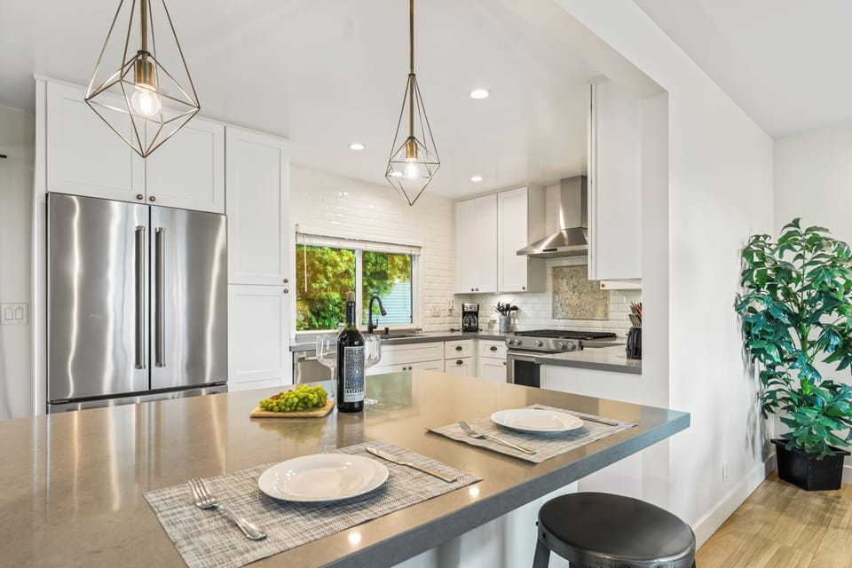 Modern kitchen with bar seating and pendant lights.