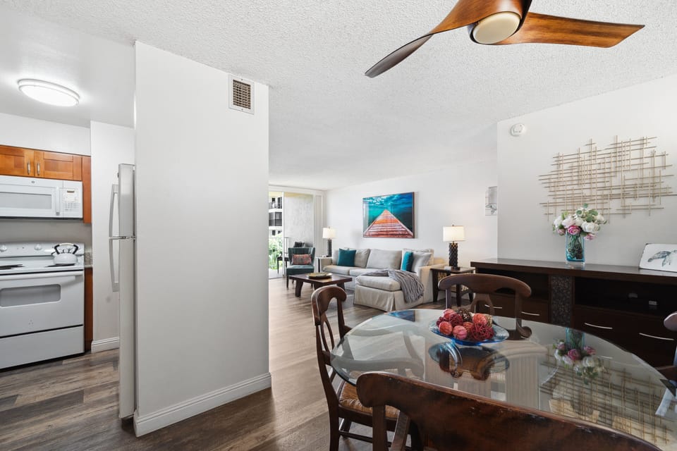 Wider view flows from dining to living room, where coastal artwork and comfy seating invite you to linger.