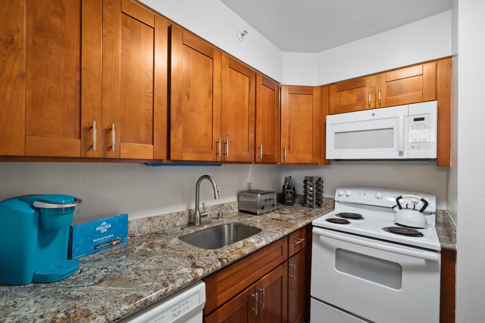 Modern kitchen with granite counters and coffee maker ready to fuel mornings before the day's adventures.