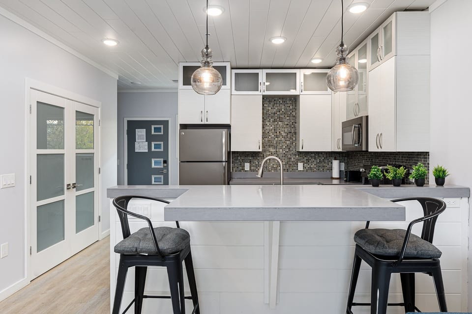 Open-concept kitchen w/ spacious island seating & clear sightlines to the entry.