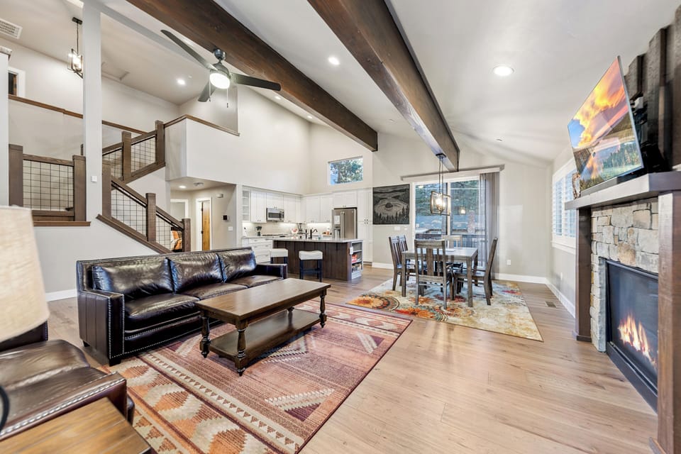 Unwind in your spacious living area with vaulted ceilings, cozy fireplace, and open kitchen perfect for memorable evenings.