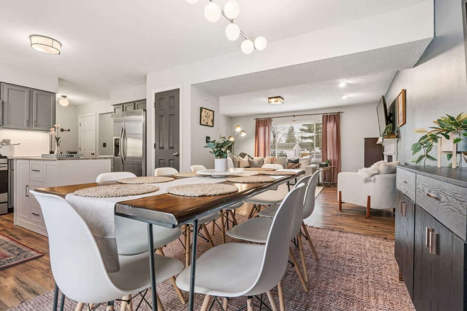 Large dining area w/ long table & open layout connecting to the kitchen.