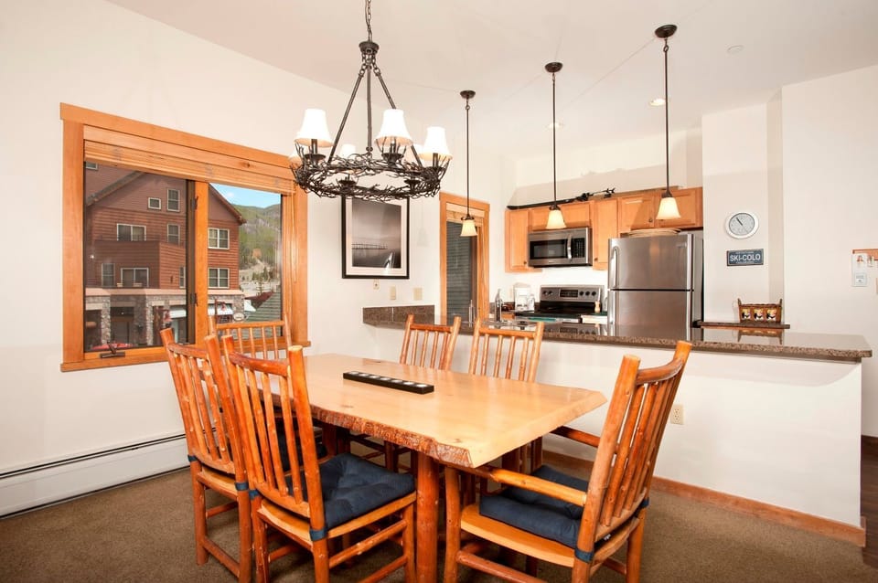 Inviting dining space with rustic wooden furniture and views of the surrounding village through large windows.