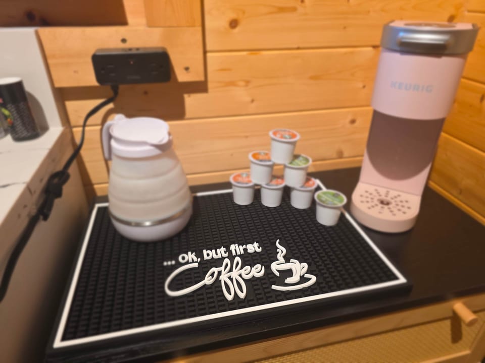 Coffee station with electric tea kettle. Kitchenette also includes mini fridge, microwave, hot plate