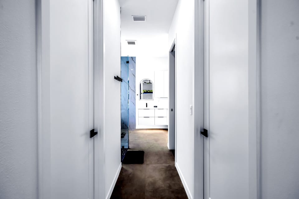 Bright modern hallway leading to a sleek spa-style bathroom