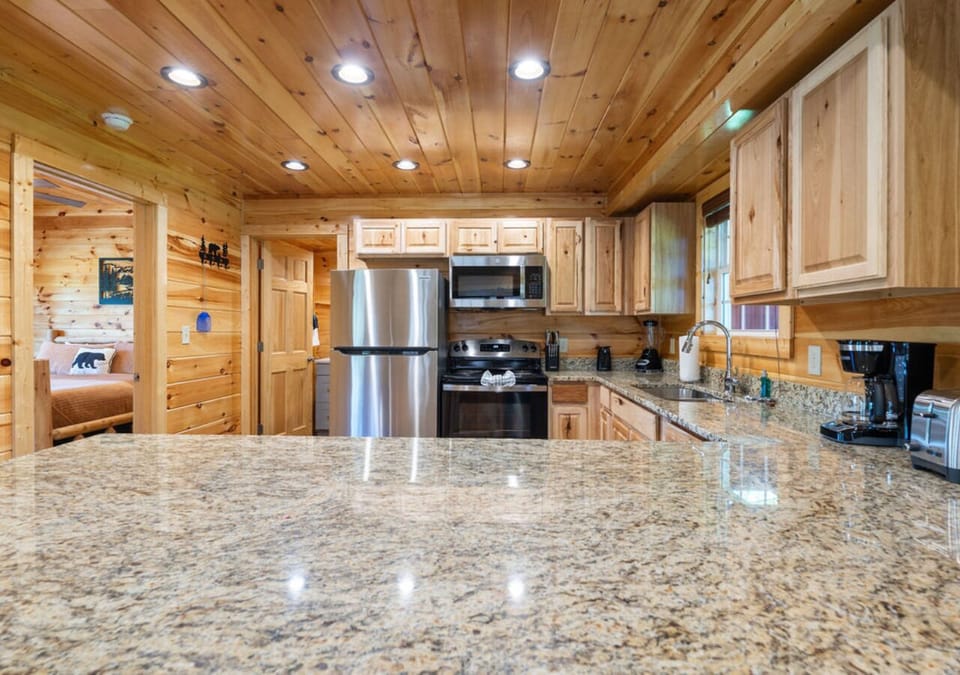 Cabin kitchen with granite counters and stainless steel appliances.
