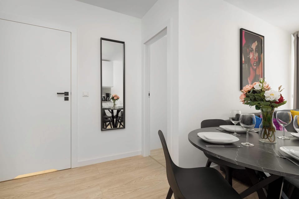 Entry hallway with a mirror, console table, and chairs arranged around the dining area.