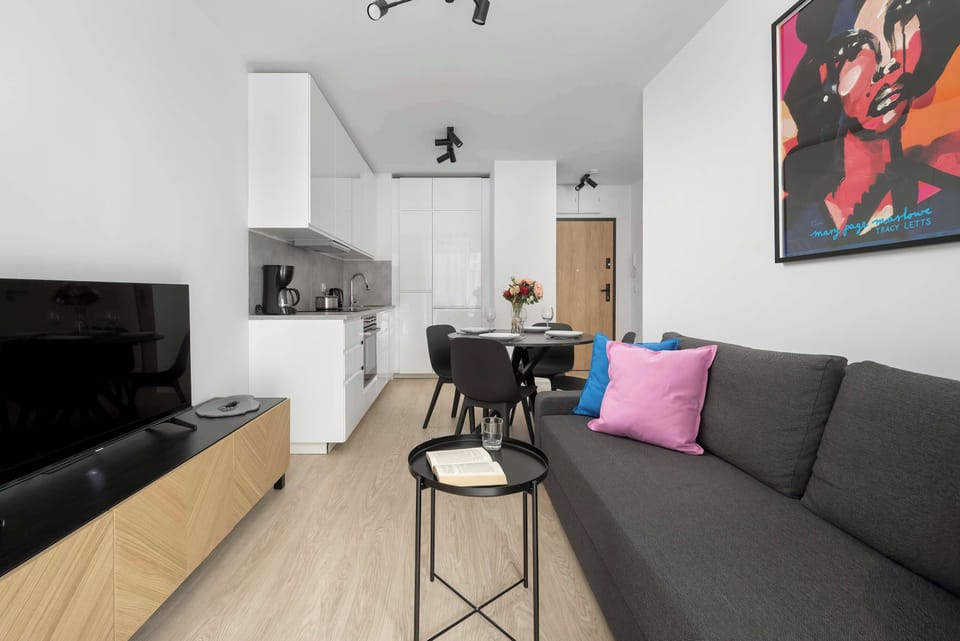 Modern living room with a sofa decorated with colorful pillows and a stylish wall painting above.
