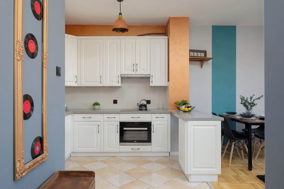 A compact yet functional kitchen with unique wall décor panels. The soft color tones make the space warm and inviting.