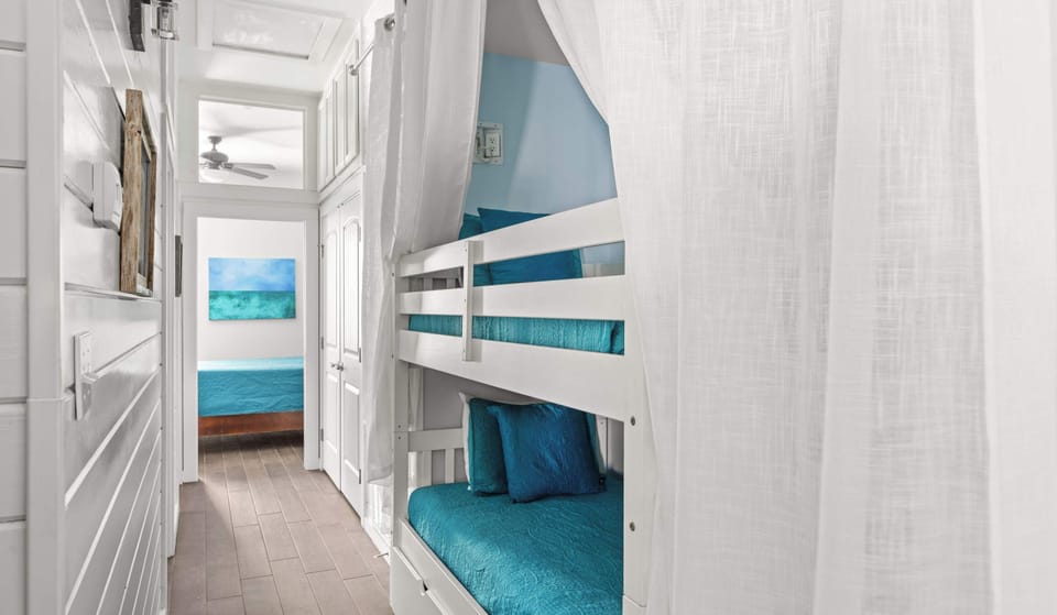 Bunk Nook — White Twin-Over-Twin Bunks, Teal Bedding, Sheer Curtain & Hallway to Bedroom