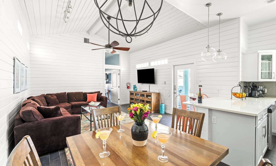Dining & Living — Wood Table with Cocktails, Orb Chandelier, Brown Sectional & Vaulted Shiplap Ceiling