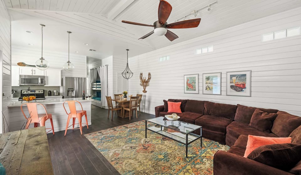 Living Room — Brown Sectional, Coral Pillows, Orange Stools, Vintage Seafood Prints & Shiplap Walls