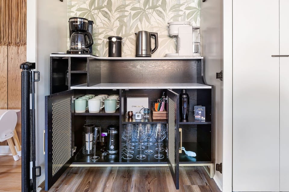 Full Coffee & Cocktail Bar! Equipped with drip coffee, Keurig, coffee grounds, a hot water kettle, and cold brew maker, a bean grinder, mugs, wine glasses, and a cocktail mixing set. 3 Keurig pods are provided as well as reusable ones!