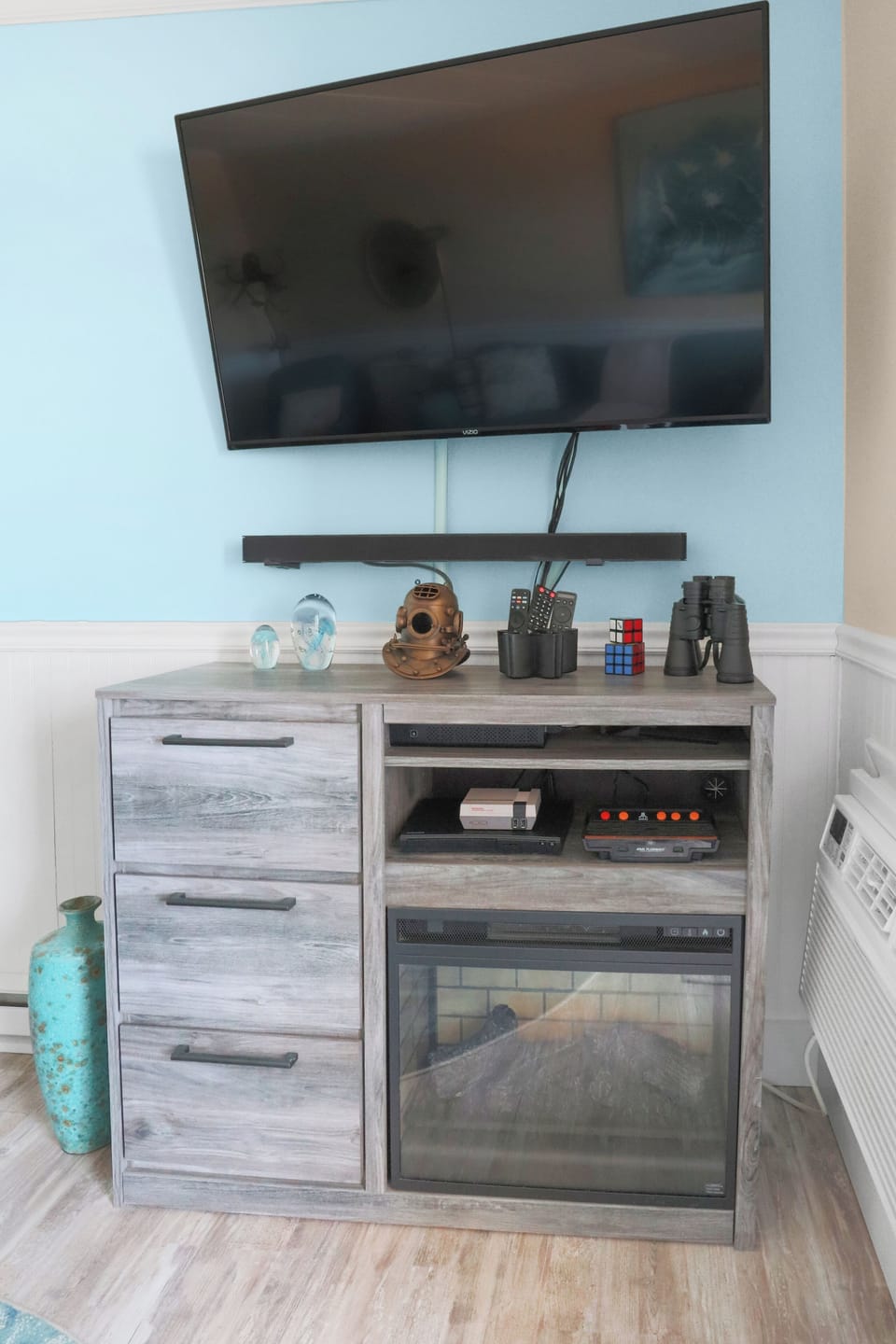 Smart TV, electric fireplace, Blu-ray/DVD player, and retro gaming consoles