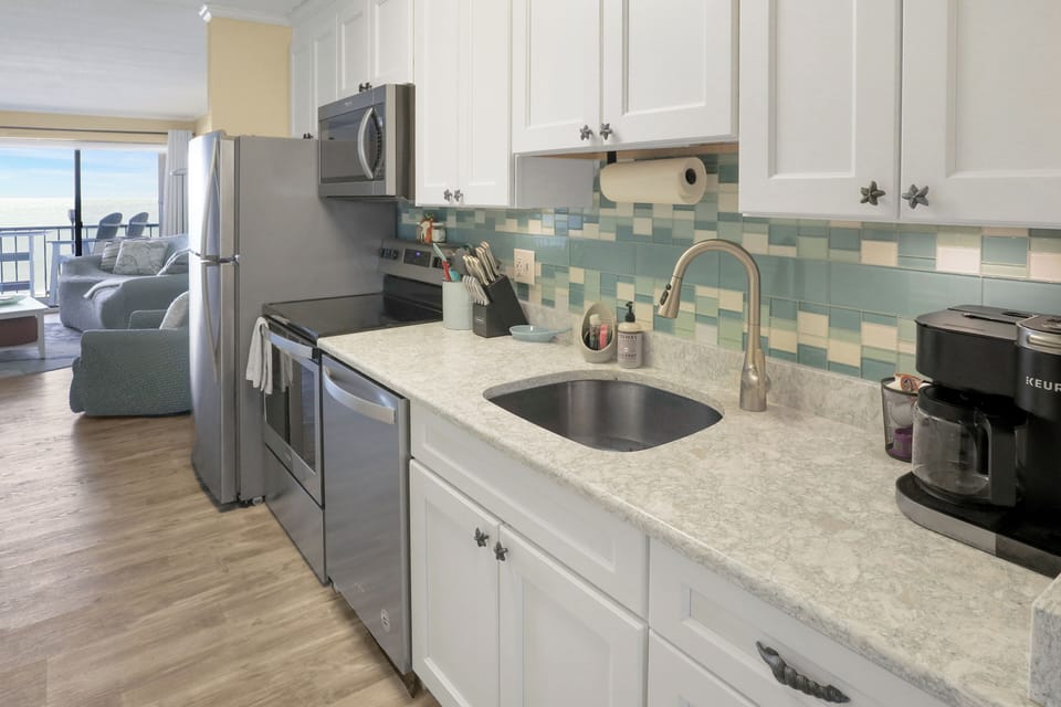 Fully equipped coastal kitchen w/ stainless appliances, quartz counters, & more