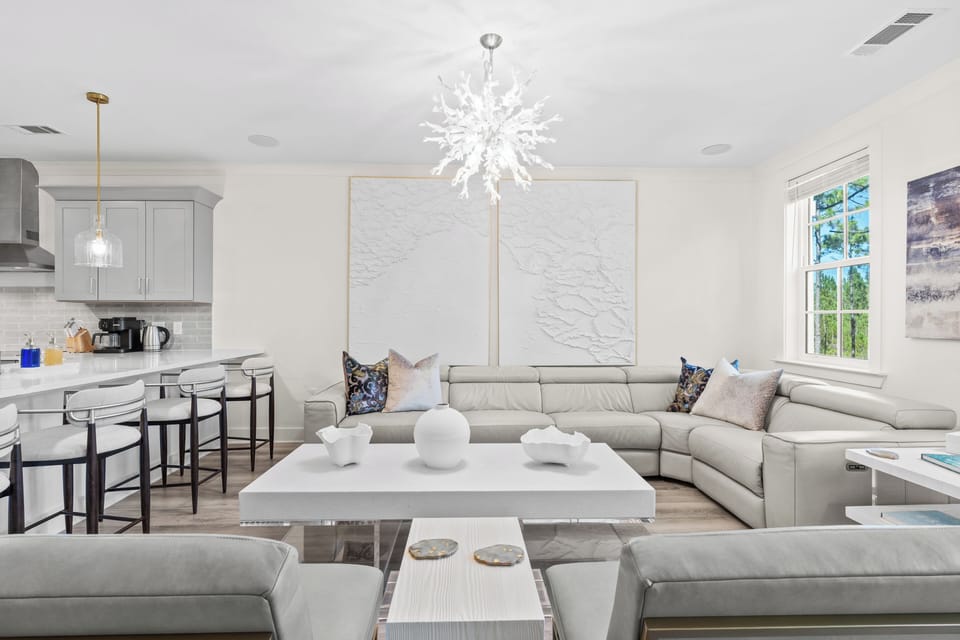 Bright, modern living room with chic décor, plush seating, and serene forest views.