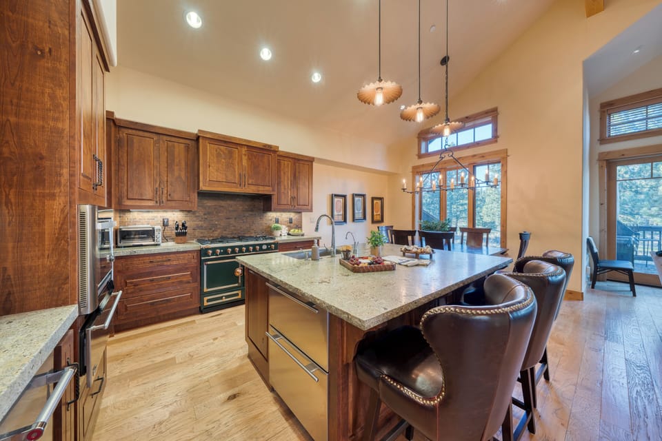 Spacious chef’s kitchen with a large island, stainless appliances, and dining for the whole group.
