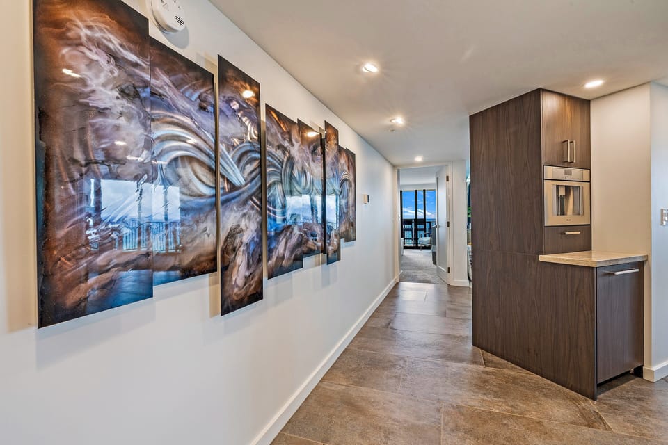 Enjoy a chic hallway featuring bold art pieces and a clean, minimalist design